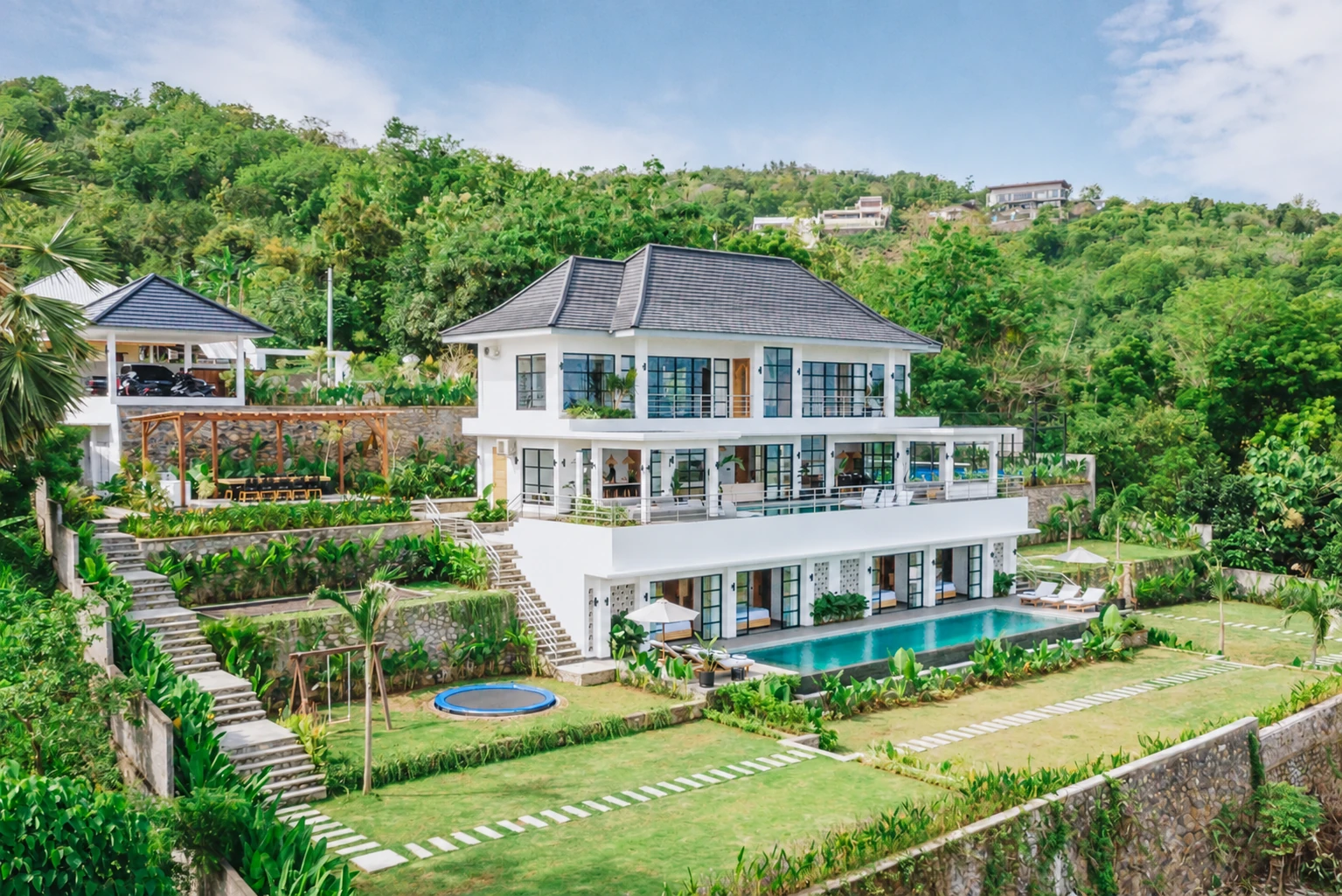 Oblique aerial showing the three villa levels, two pools, garden and hillside pergola.