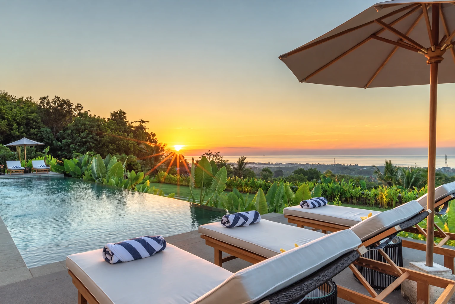 Pool terrace at sunset overlooking the Bali Sea.